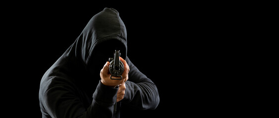 Portrait killer hacker mafia gangster spy man one person in black hoodie standing look hand holding...