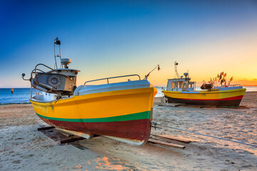 Naklejka na ściany i meble Fishing boats on the beach of Baltic Sea in Sopot at sunrise, Poland