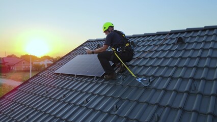 Engineer checking data on tablet, while installing solar panels on a private house roof - Aerial view