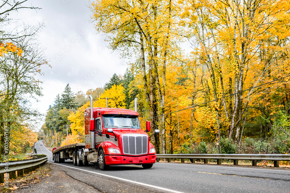 Poster red big rig bonnet semi truck tractor with extended cab and empty flat bed semi trailer running on t