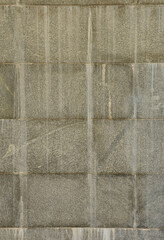 The texture of a wall of large granite tiles that are covered with white streaks when exposed to...