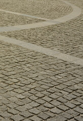 The texture of the paving slab (paving stones) of many small stones of a square shape under bright...