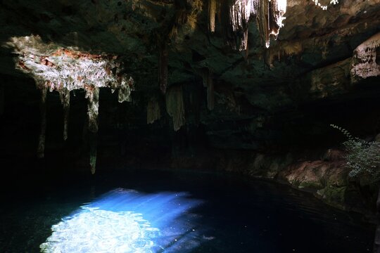 Sinkhole, Cenote with incidence of sunlight, stalactites on the cave ceiling and blue water pool