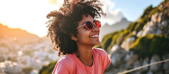 Cheerful mixed race girl wearing heart-shaped sunglasses and a pink t-shirt, happily smiling on vacation.