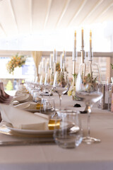 Serving the festive table at a wedding event. Decorating the wedding table with bouquets of flowers. Cutlery at a party 