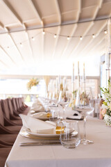 Serving the festive table at a wedding event. Decorating the wedding table with bouquets of flowers. Cutlery at a party 
