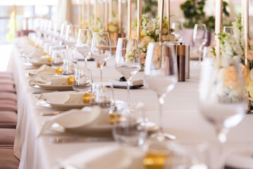 Serving the festive table at a wedding event. Decorating the wedding table with bouquets of flowers. Cutlery at a party 