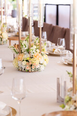 Serving the festive table at a wedding event. Decorating the wedding table with bouquets of flowers. Cutlery at a party 