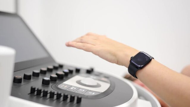 Video with close-up of a female cardiologist monitoring a heart performing an echocardiogram