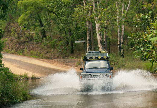 COOKTOWN, FAR NORTH QUEENSLAND, AUSTRALIA. September 12th, 2022. Nissan patrol 4x4 crossing a flooded causeway after recent storms.
