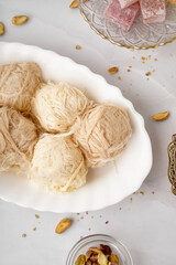 Plate with tasty Turkish Pismaniye on light background, closeup
