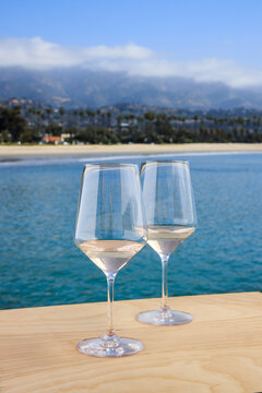 Two glasses of white wine overlooking the beach and mountains in Santa Barbara, California