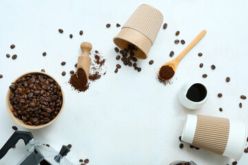 Cups, bowl and scoop with coffee beans on light background