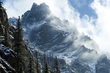 Amidst a rugged alpine landscape, a majestic mountain looms over a frozen wilderness, its snow-capped summit obscured by swirling clouds as towering spruce trees cling to the steep terrain