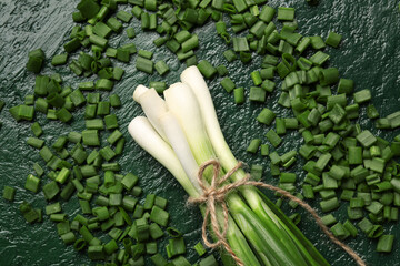 Fresh green onion and slices on color background