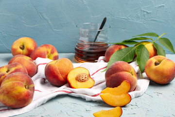 Many sweet peaches and leaves on blue background