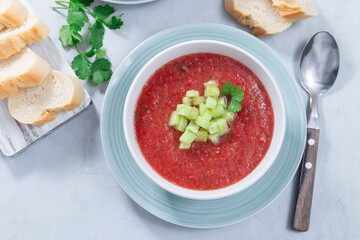 Cold soup Gazpacho garnished with cucumber and cilantro, in bowl, horizontal top view