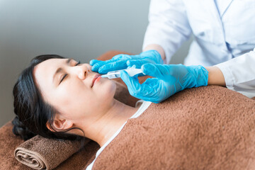 ガミースマイル治療・鼻下・上唇にボトックス・ヒアルロン酸・脂肪溶解注射を打つ患者と美容外科の医師  © buritora