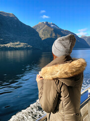 Capturing the essence of tranquility, a woman gazes at the breathtaking Doubtful Sound scenery from...