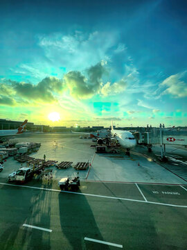 Changi Airport, Singapore - March 3 2023: Aviation at Singapore Changi Airport, where a Qantas A330 graces the tarmac against a breathtaking sunset seen from the terminal window
