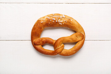 Soft pretzel on white wooden background