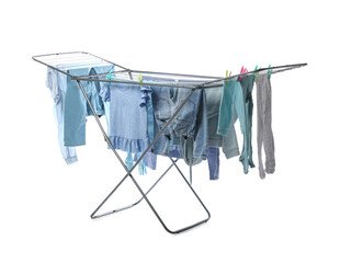 Different children's clothes hanging on dryer against white background