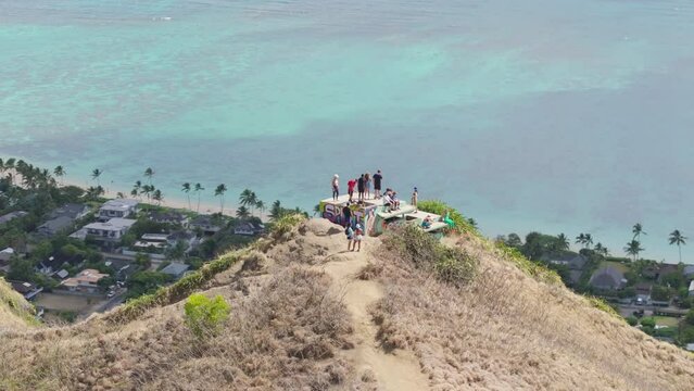 People enjoying cinematic views of Lanikai beach standing on top of Pillbox Trail on Hawaii. Aerial adventurous tourists on top of Kaiwa Ridge Trail on Oahu island Hawaii. Outdoor adventure concept 4K
