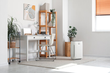 Interior of modern office with air purifier and workplace