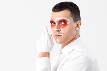 Young man with painted face on white background, closeup