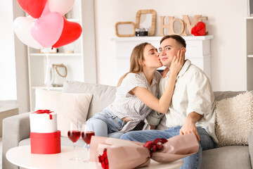 Beautiful young happy couple celebrating Valentine's Day at home
