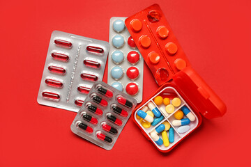 Different pills on red background