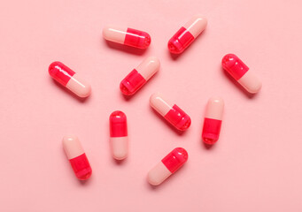 Medical capsules on pink background
