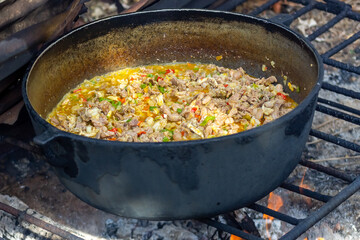 Preparation of pilaf in a cauldron on the fire