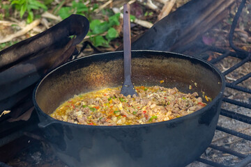 Preparation of pilaf in a cauldron on the fire