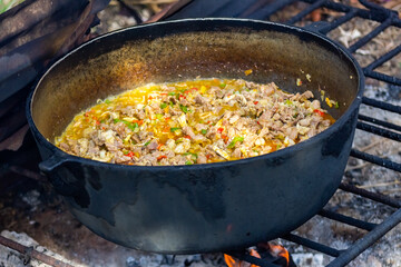Preparation of pilaf in a cauldron on the fire
