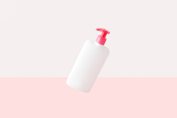 Bottle of intimate hygiene gel on pastel pink and white background. Body care concept