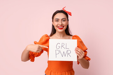 Beautiful young pin-up woman holding paper with text GRL PWR on pink background