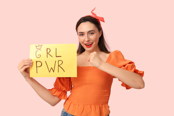 Beautiful young pin-up woman holding paper with text GRL PWR on pink background