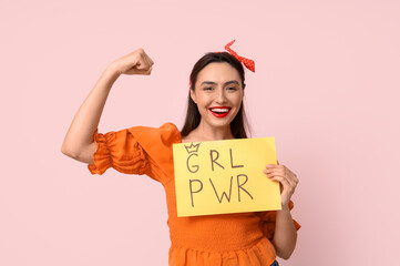 Beautiful young pin-up woman holding paper with text GRL PWR on pink background