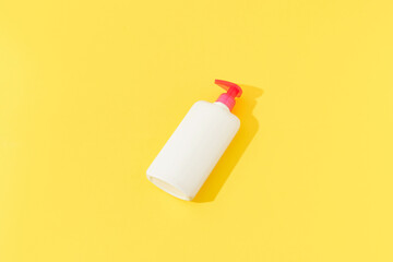 Bottle of intimate hygiene gel on yellow background. Body care concept