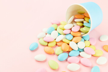 Traditional Easter Portuguese candies. Colorful Sweets in a blue paper cup on pink background