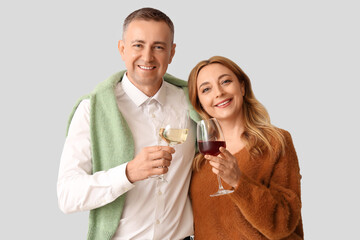 Mature couple with glasses of wine on white background