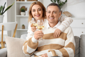 Mature couple with glasses of wine at home