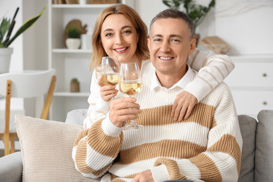 Mature couple with glasses of wine at home - Powered by Adobe