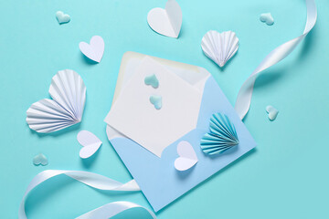 Composition with blank card, paper hearts and ribbon on color background. Valentine's Day celebration