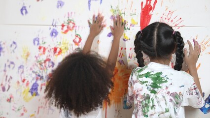 Playful children playing and running with colorful stained hand in front of white background. Funny...