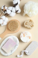 Fototapeta na wymiar Bath accessories. Flat lay composition with personal care products and cotton flowers on beige background