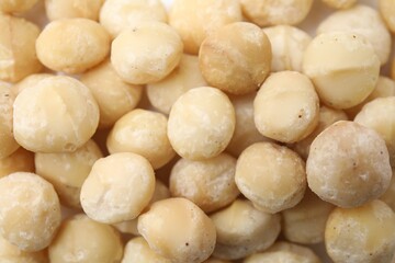 Tasty peeled Macadamia nuts as background, top view