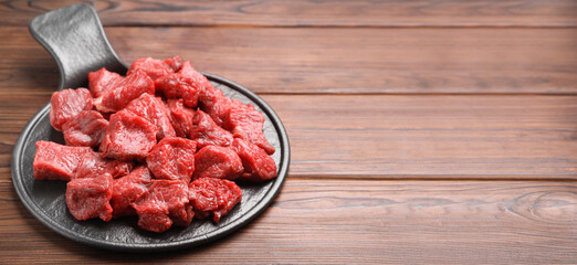 Pieces of raw beef meat on wooden table. Banner design with space for text