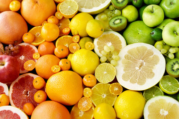 Colorful bright background of fresh ripe sweet citrus fruits: orange and tangerine, green lime and...